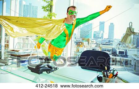 Superhero flying in office View Large Photo Image Stock Photo - Superhero flying in office. Fotosearch