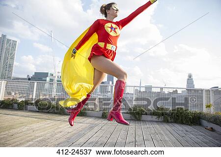 Superhero jumping on city rooftop View Large Photo Image Stock Photo - Superhero jumping on city rooftop. Fotosearch