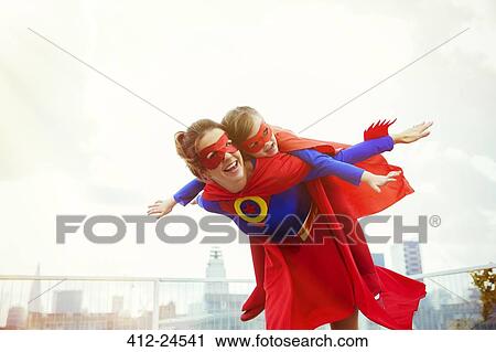 Superhero mother and daughter playing on city rooftop View Large Photo Image Stock Image - Superhero mother and daughter playing on city rooftop. Fotosearch