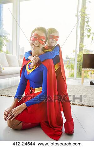 Superhero mother and son smiling in living room View Large Photo Image Picture - Superhero mother and son smiling in living room. Fotosearch