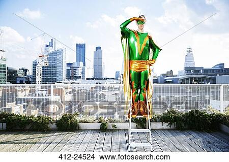 Superhero overlooking view from stepladder on city rooftop View Large Photo Image Picture - Superhero overlooking view from stepladder on city rooftop. Fotosearch