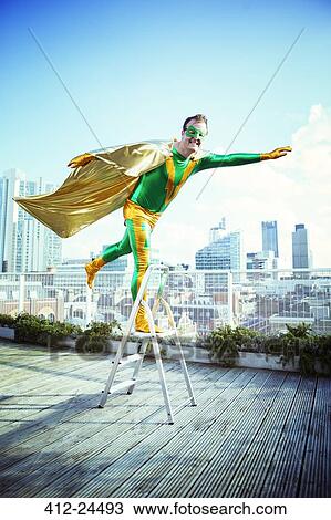 Superhero posing on stepladder on city rooftop View Large Photo Image Stock Image - Superhero posing on stepladder on city rooftop. Fotosearch