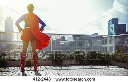 Superhero standing on city rooftop View Large Photo Image Stock Image - Superhero standing on city rooftop. Fotosearch