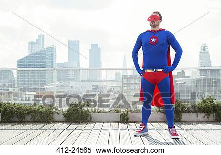 Superhero standing with hands on hips on city rooftop View Large Photo Image Stock Photography - Superhero standing with hands on hips on city rooftop. Fotosearch