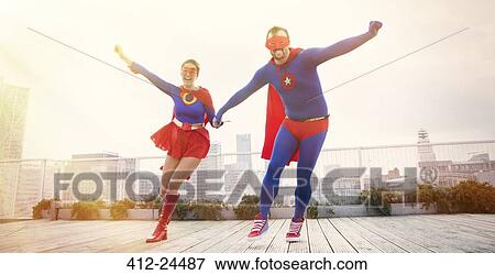 Superheroes holding hands running on city rooftop View Large Photo Image Stock Photo - Superheroes holding hands running on city rooftop. Fotosearch
