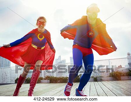 Superheroes running on city rooftop View Large Photo Image Stock Photo - Superheroes running on city rooftop. Fotosearch