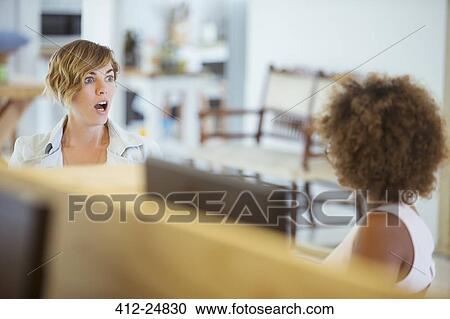"Female colleagues talking in office, feeling surprised" View Large Photo Image Stock Image - "Female colleagues talking in office, feeling surprised". Fotosearch