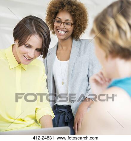 "Female office team using laptop, talking and smiling" View Large Photo Image Stock Image - "Female office team using laptop, talking and smiling". Fotosearch