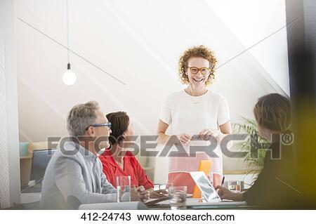 Stock Image - Four people at meeting in office. Fotosearch