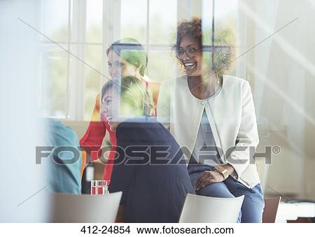 Group of office workers talking at desk View Large Photo Image Picture - Group of office workers talking at desk. Fotosearch