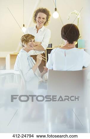 Picture - Office workers having lunch together. Fotosearch