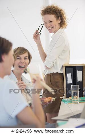 Stock Photograph - Office workers having lunch together. Fotosearch