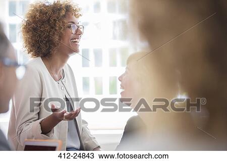 Stock Image - Office workers talking at meeting. Fotosearch