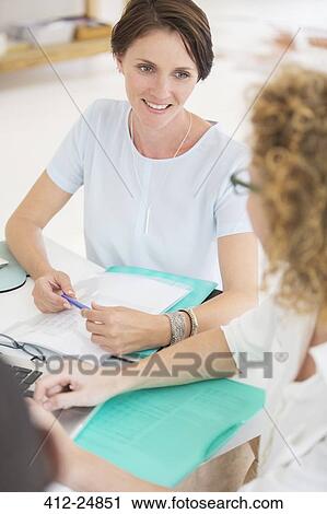 Office workers talking at meeting View Large Photo Image Stock Image - Office workers talking at meeting. Fotosearch
