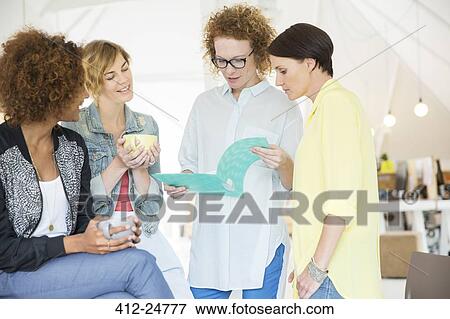 Office workers talking over file View Large Photo Image Stock Photo - Office workers talking over file. Fotosearch