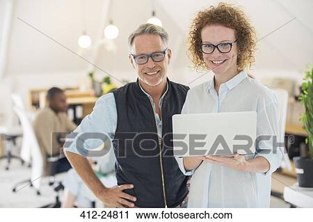 "Portrait of man and woman with laptop, smiling in office" View Large Photo Image Stock Image - "Portrait of man and woman with laptop, smiling in office". Fotosearch