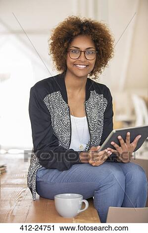 Stock Image - Portrait of smiling office worker with digital tablet. Fotosearch