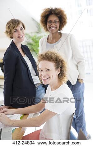 "Portrait of three women in office, smiling" View Large Photo Image Picture - "Portrait of three women in office, smiling". Fotosearch