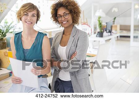 Stock Image - Portrait of two smiling office workers. Fotosearch