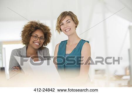 Stock Image - Portrait of two smiling office workers. Fotosearch