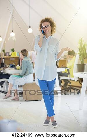 Portrait of woman talking on phone at office View Large Photo Image Stock Photo - Portrait of woman talking on phone at office. Fotosearch