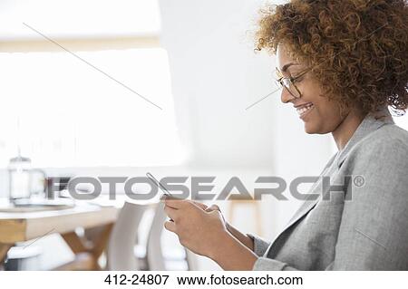 Stock Photo - Portrait of woman using smart phone and smiling. Fotosearch