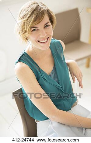 Portrait of young woman smiling at office View Large Photo Image Picture - Portrait of young woman smiling at office. Fotosearch