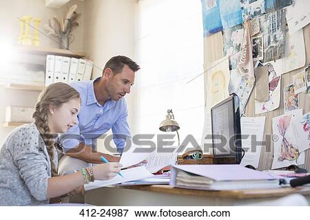Stock Photo - Father helping teenage daughter with her homework. Fotosearch