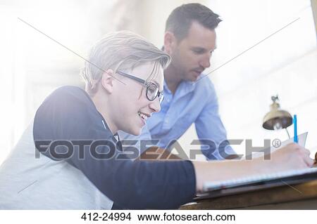 Picture - Father helping teenage son with his homework. Fotosearch