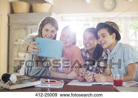 Group of smiling teenagers taking selfie in dining room View Large Photo Image Stock Photo - Group of smiling teenagers taking selfie in dining room. Fotosearch