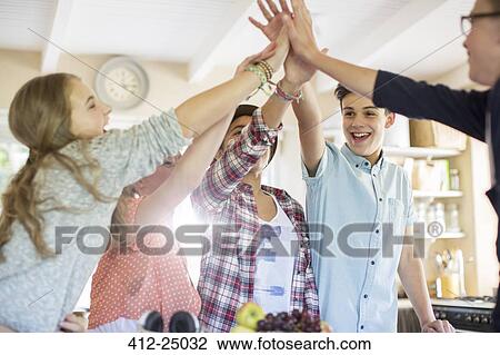 Group of teenagers doing high five in living room View Large Photo Image Stock Image - Group of teenagers doing high five in living room. Fotosearch
