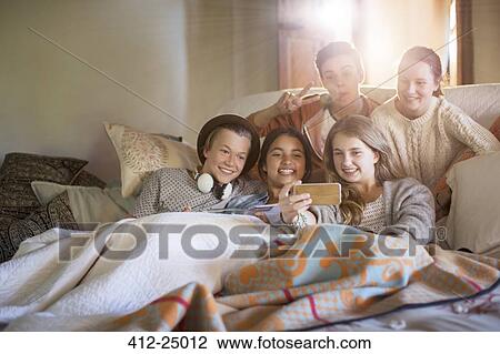 Group of teenagers taking selfie on sofa in living room View Large Photo Image Stock Image - Group of teenagers taking selfie on sofa in living room. Fotosearch