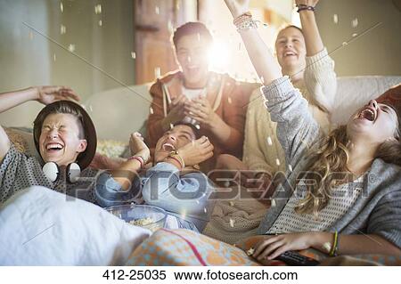 Group of teenagers throwing popcorn on themselves on sofa View Large Photo Image Stock Photography - Group of teenagers throwing popcorn on themselves on sofa. Fotosearch