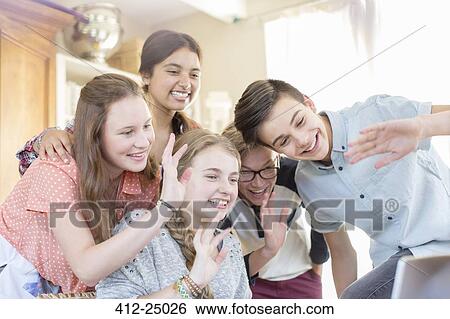 Stock Photograph - Group of teenagers waving while communicating via internet. Fotosearch