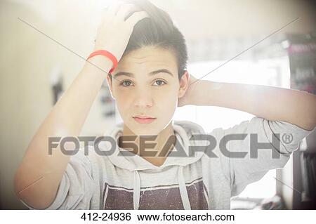 Stock Photograph - Portrait of teenage boy with hand in hair. Fotosearch