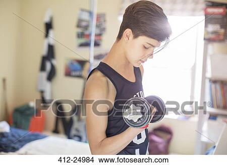 Teenage boy exercising with dumb bell View Large Photo Image Picture - Teenage boy exercising with dumb bell. Fotosearch