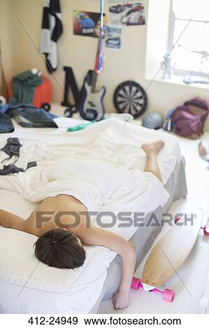Teenage boy sleeping in bed in his messy room View Large Photo Image Stock Photo - Teenage boy sleeping in bed in his messy room. Fotosearch