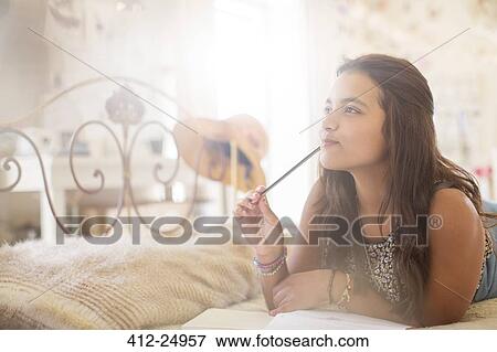 Stock Photo - Teenage girl lying on bed and thinking. Fotosearch