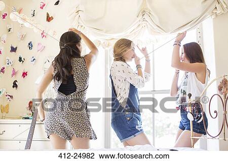 Three teenage girls dancing on bed in bedroom View Large Photo Image Stock Image - Three teenage girls dancing on bed in bedroom. Fotosearch
