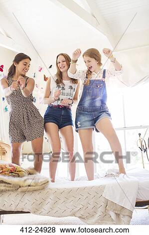 Three teenage girls dancing on bed in bedroom View Large Photo Image Stock Photo - Three teenage girls dancing on bed in bedroom. Fotosearch
