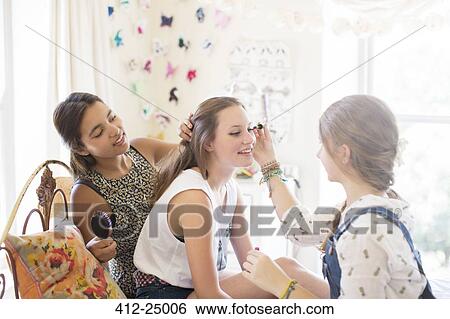 Three teenage girls doing make up and brushing hair in bedroom View Large Photo Image Stock Photograph - Three teenage girls doing make up and brushing hair in bedroom. Fotosearch