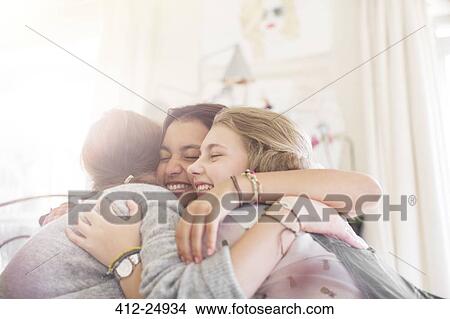 Three teenage girls embracing at home View Large Photo Image Picture - Three teenage girls embracing at home. Fotosearch