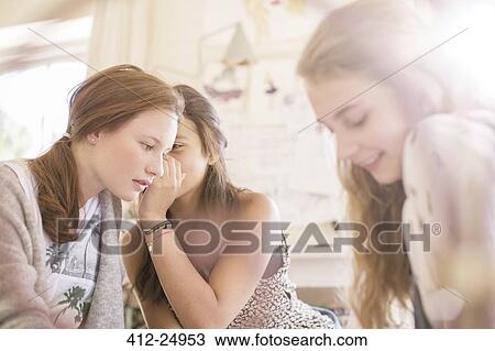Three teenage girls gossiping in room View Large Photo Image Stock Image - Three teenage girls gossiping in room. Fotosearch