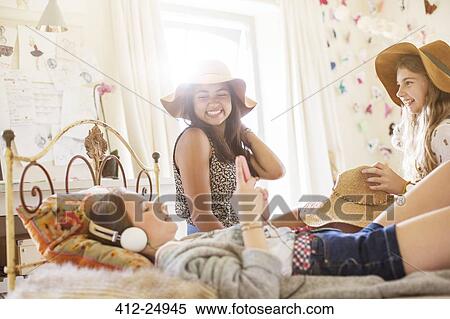 Three teenage girls having fun on bed in bedroom View Large Photo Image Stock Photography - Three teenage girls having fun on bed in bedroom. Fotosearch