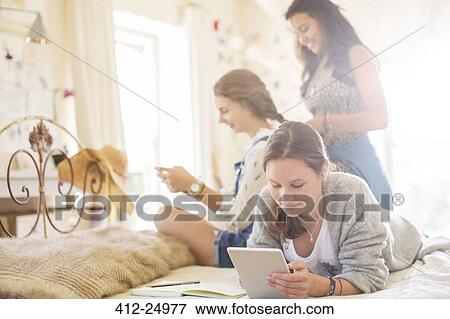 Three teenage girls relaxing in bedroom View Large Photo Image Stock Photo - Three teenage girls relaxing in bedroom. Fotosearch