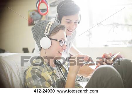 Two teenage boys listening to music on headphones View Large Photo Image Stock Image - Two teenage boys listening to music on headphones. Fotosearch