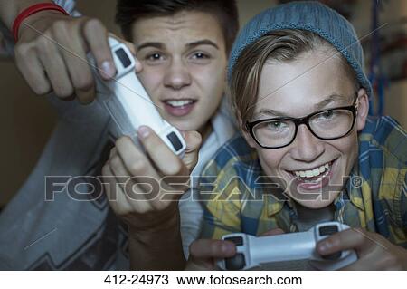 Two teenage boys playing together video game View Large Photo Image Stock Image - Two teenage boys playing together video game. Fotosearch