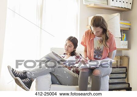 Two teenage girls doing homework in room View Large Photo Image Picture - Two teenage girls doing homework in room. Fotosearch