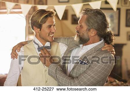Stock Photo - Best man and bridegroom standing and embracing in domestic room. Fotosearch