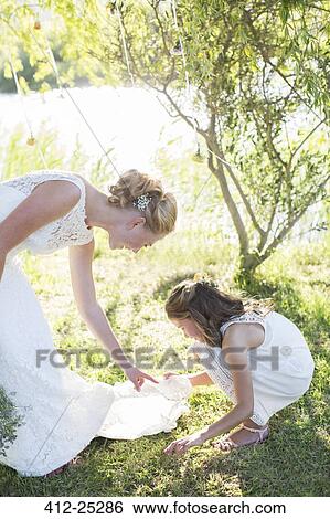 Bride and bridesmaid in domestic garden during wedding reception View Large Photo Image Stock Photograph - Bride and bridesmaid in domestic garden during wedding reception. Fotosearch